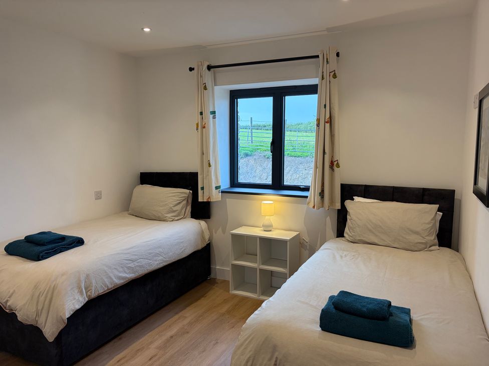 A bedroom with two single beds and a lamp at High View Barn in Launceston