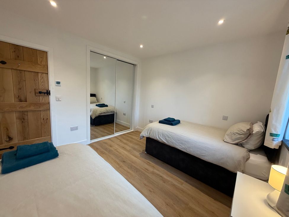 A bedroom with two beds and a wardrobe at High View Barn in Launceston
