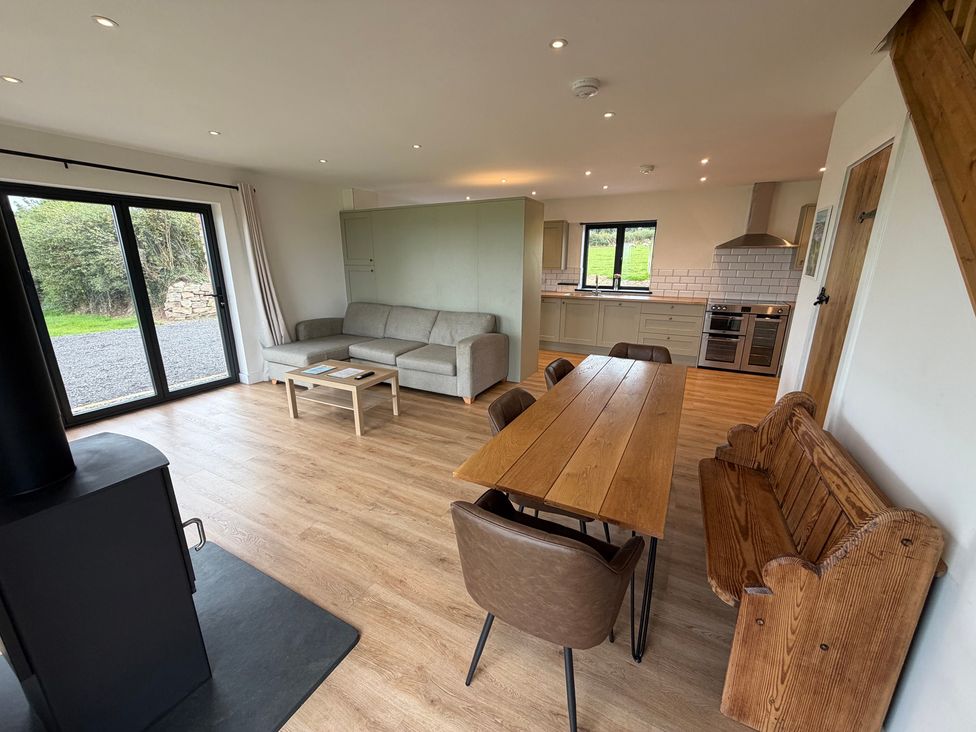 A living room with a dining table and kitchen area at High View Barn in Launceston