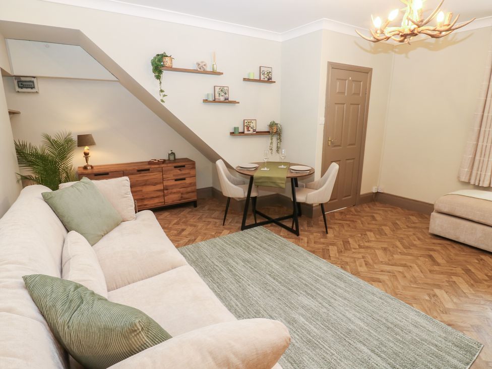 A living room with a sofa and dining area at Corner House in Wark