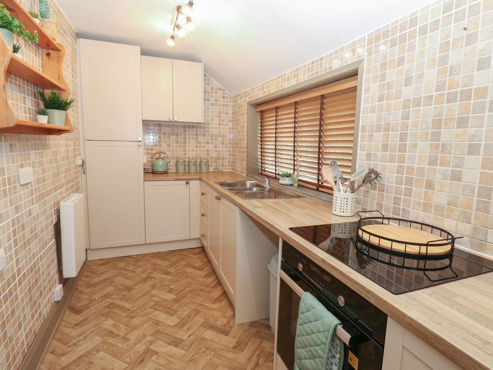 A kitchen with cabinets and a sink at Corner House in Wark