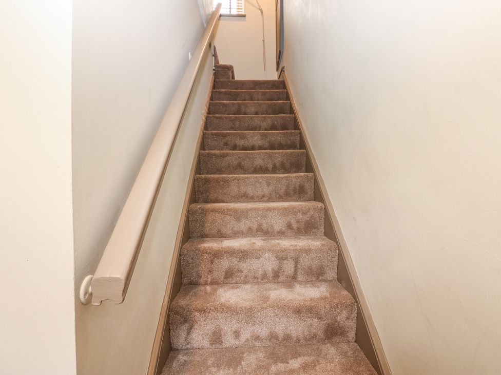 A staircase with carpet and handrail at Corner House in Wark