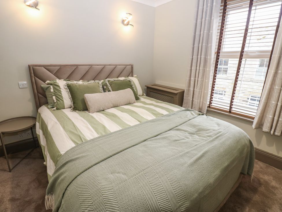 A bedroom with a bed and nightstand at Corner House Wark