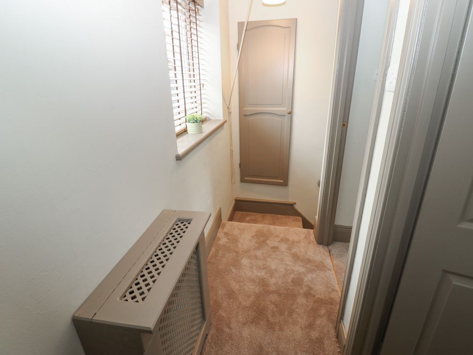 A hallway with a radiator and stairs at Corner House in Wark