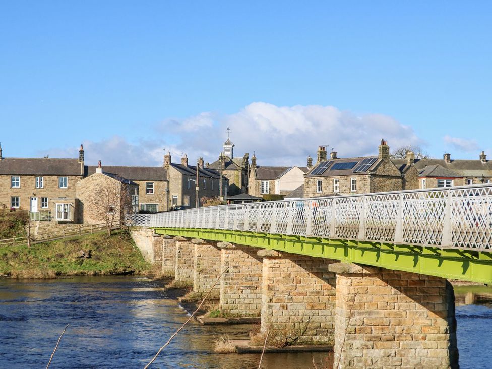 A bridge over a river with houses beside it at Corner House in Wark