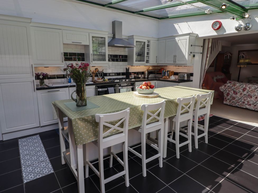 A kitchen with a counter and stools at 11b Market Street Narberth