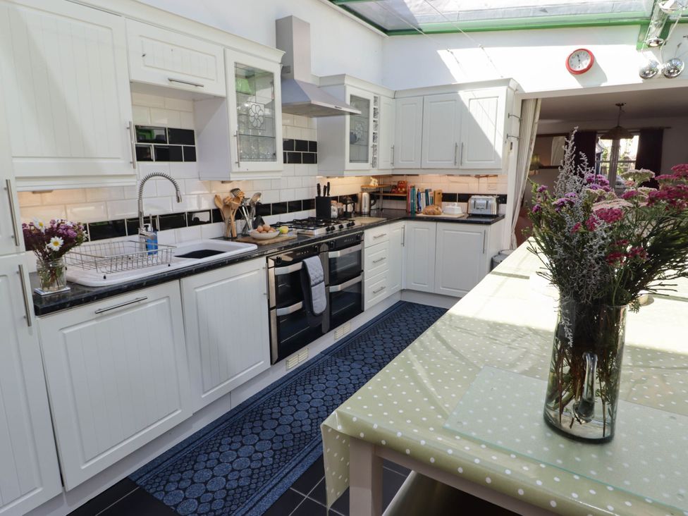 A kitchen with appliances and a flower vase at 11b Market Street Narberth