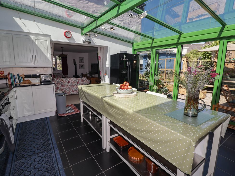 A kitchen with a central table and chairs at 11b Market Street, Narberth