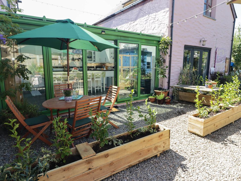 A garden with a table, chairs and planters at 11b Market Street Narberth