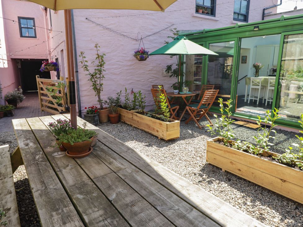 A garden with wooden furniture and plants at 11b Market Street Narberth