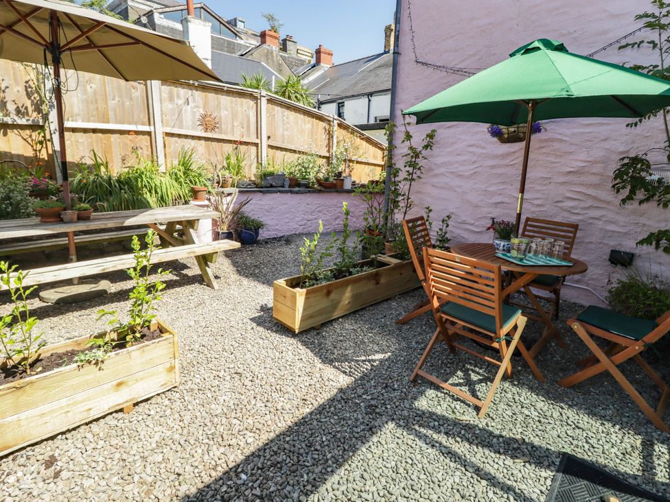 A garden with table and chairs under umbrellas at 11b Market Street Narberth
