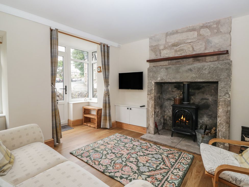 A living room with a fireplace and television at Bluebell Cottage in Heysham