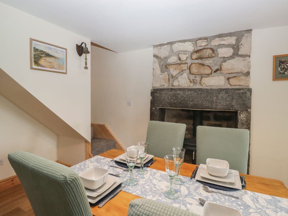 A dining room with a table set for meals at Bluebell Cottage in Heysham