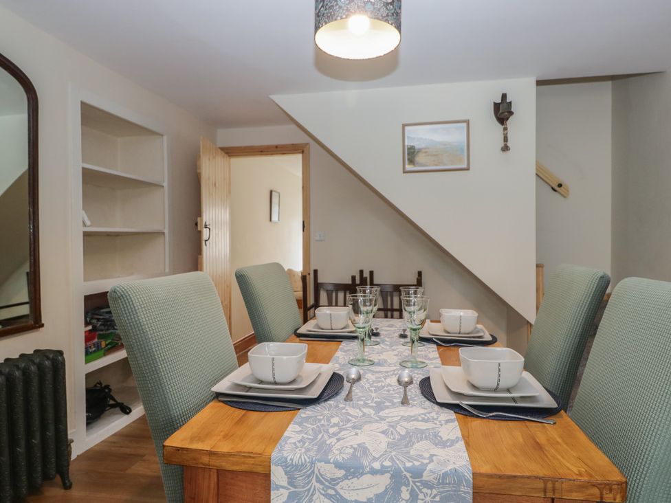 A dining room with a table set for dinner at Bluebell Cottage in Heysham