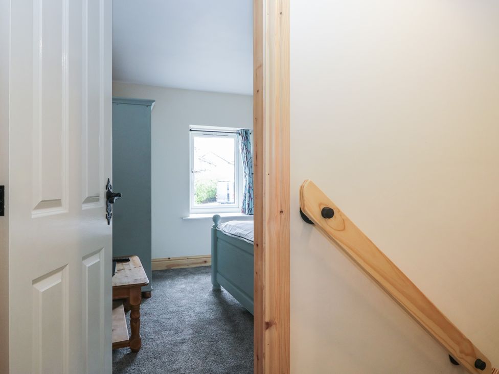 A bedroom with a bed and a window at Bluebell Cottage in Heysham