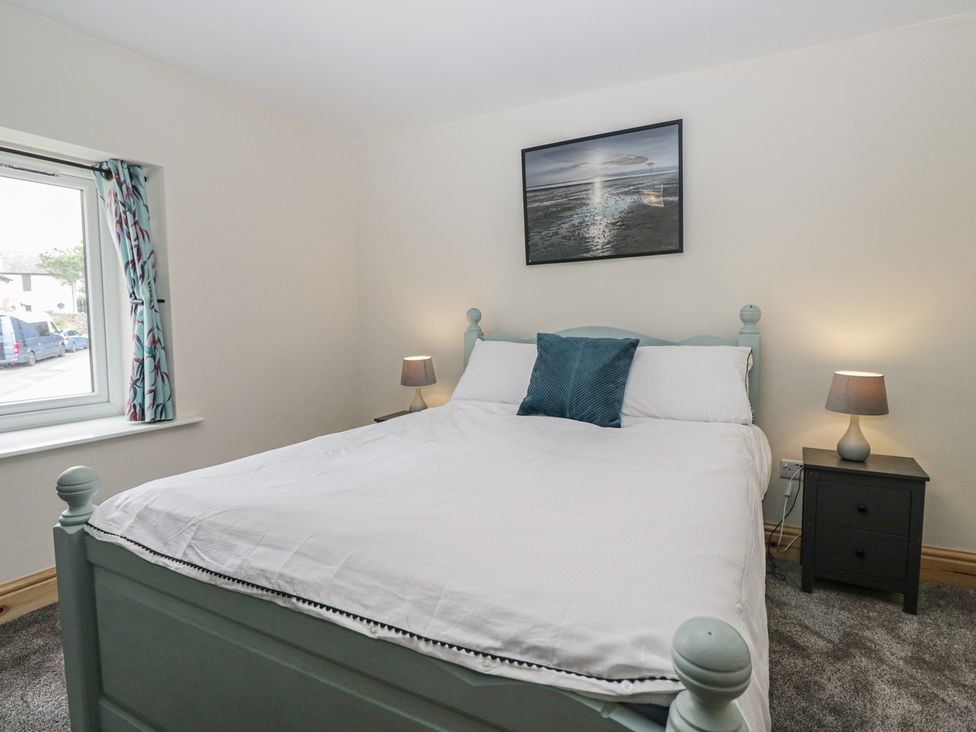 A bedroom with a bed and bedside tables at Bluebell Cottage in Heysham