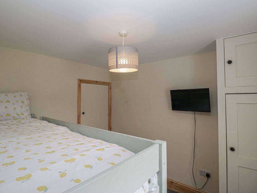 A bedroom with a bed and TV at Bluebell Cottage in Heysham