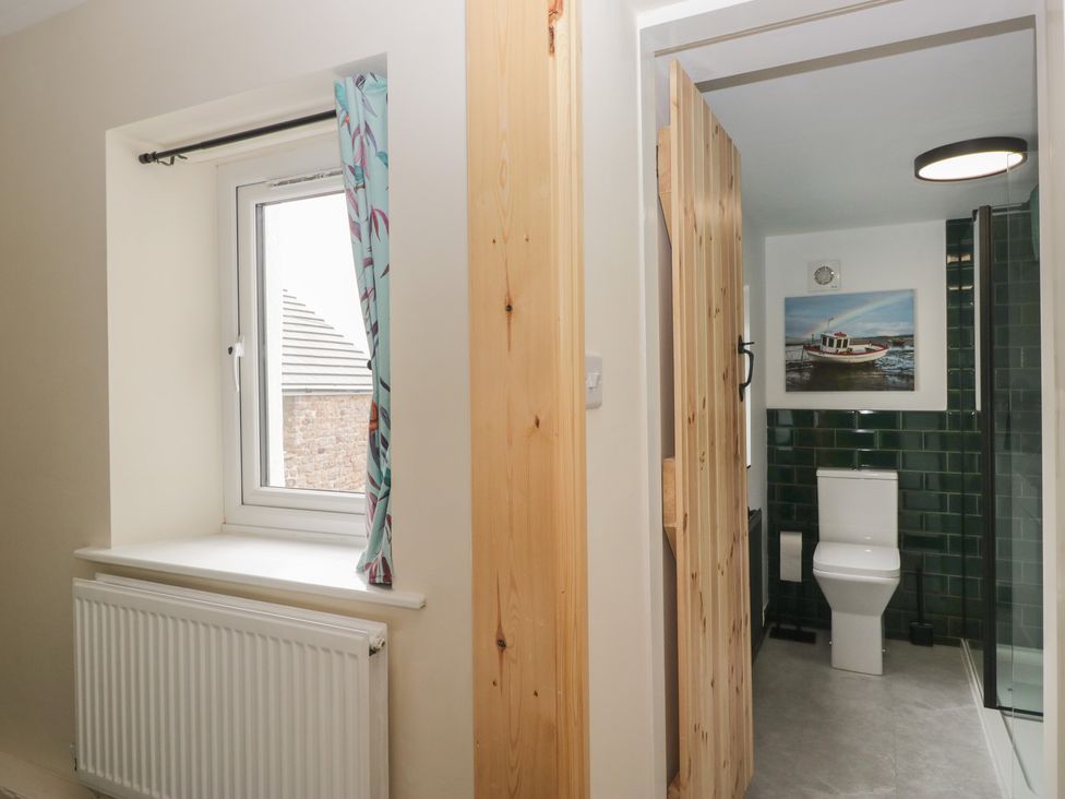 A bathroom with a toilet, sink, and shower in Bluebell Cottage Heysham