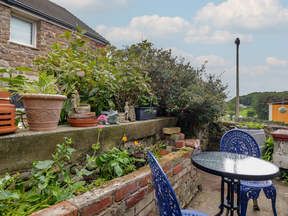 A garden area with a table and chairs at Bluebell Cottage in Heysham