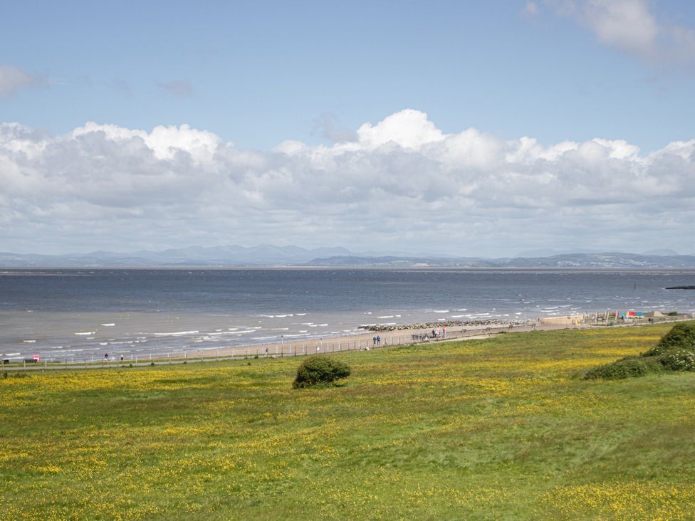 A beach with water and clouds at Bluebell Cottage in Heysham
