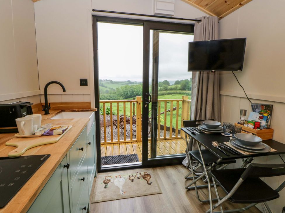 A kitchen with a dining table and a view at The Hut in Llandysul