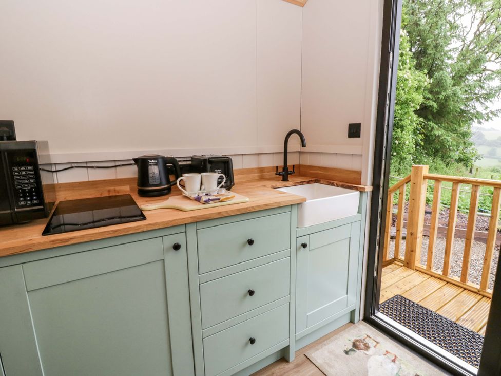 A kitchen with appliances and a view at The Hut in Llandysul