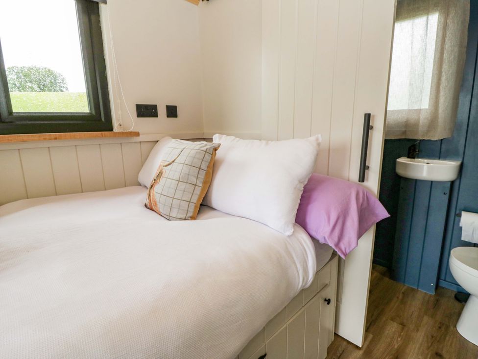 A bedroom with a bed and a sink at The Hut in Llandysul