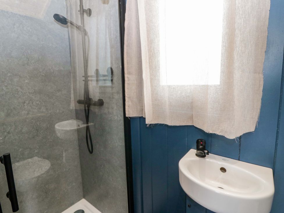 A bathroom with a shower and sink at The Hut in Llandysul