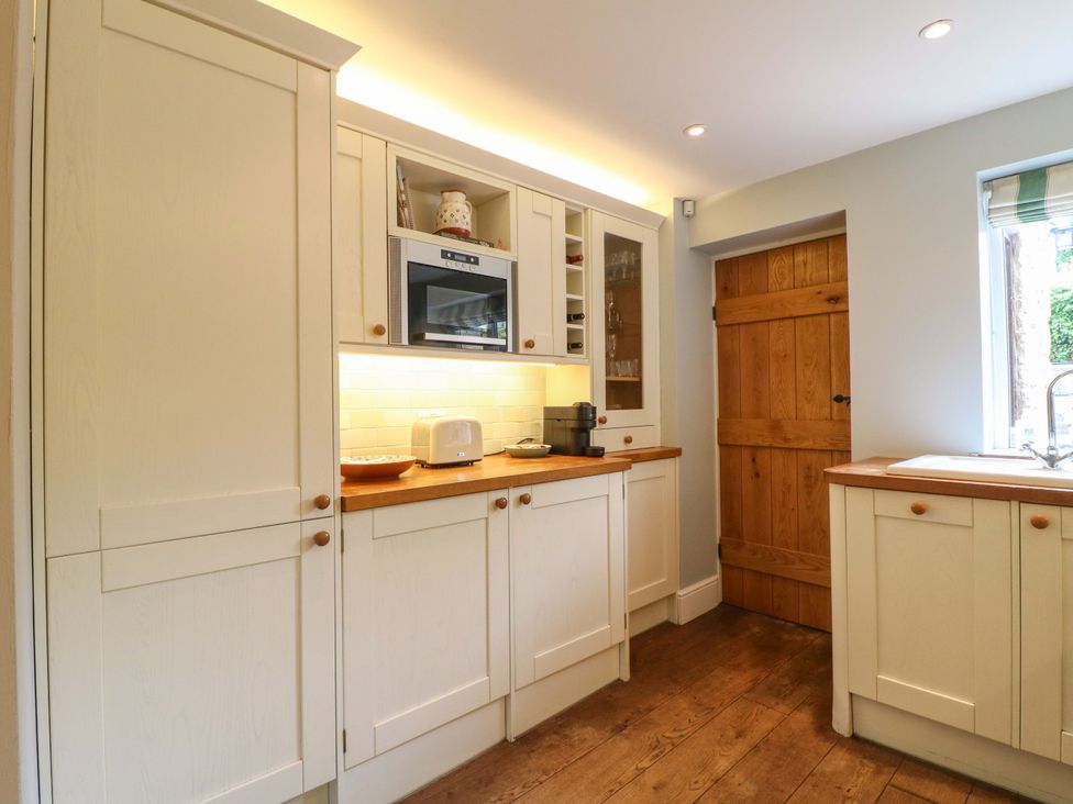 A kitchen with cabinets, a microwave, and a sink at The Chimes in Hope Valley