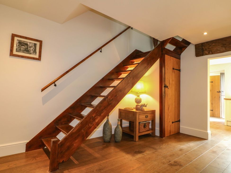 A staircase with a side table and lamp in a hallway at The Chimes in Hope Valley