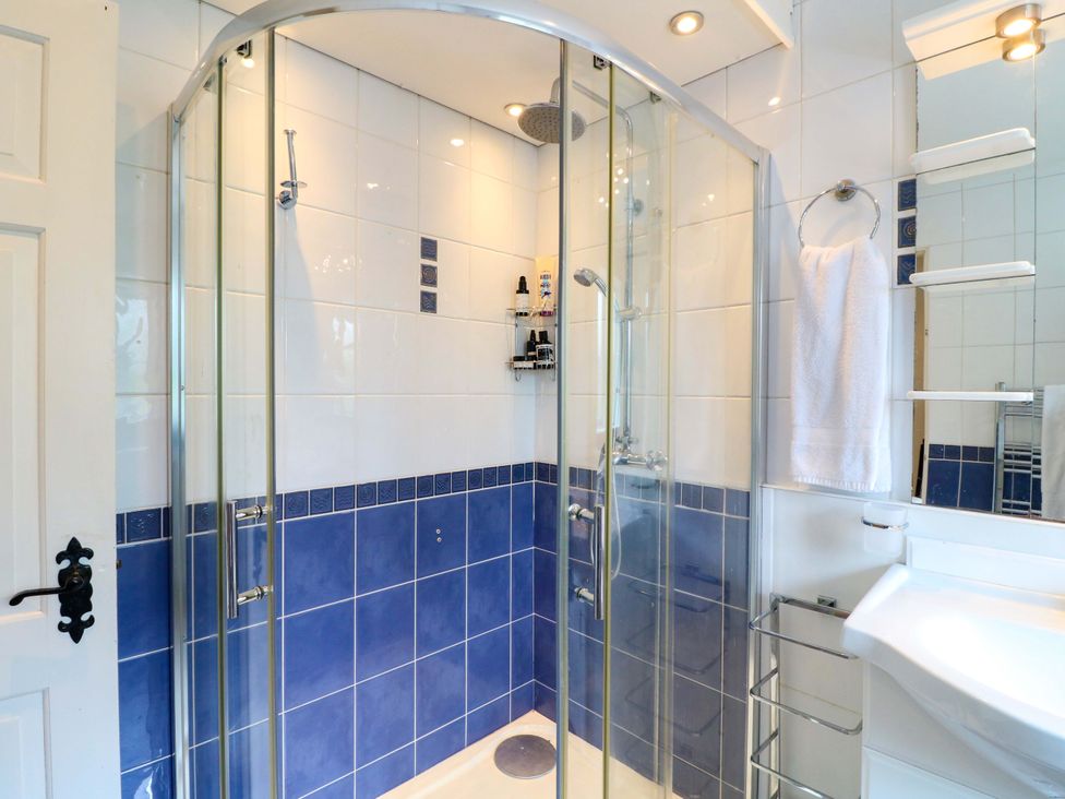 A shower stall with glass doors and a sink in the bathroom at The Chimes in Hope Valley