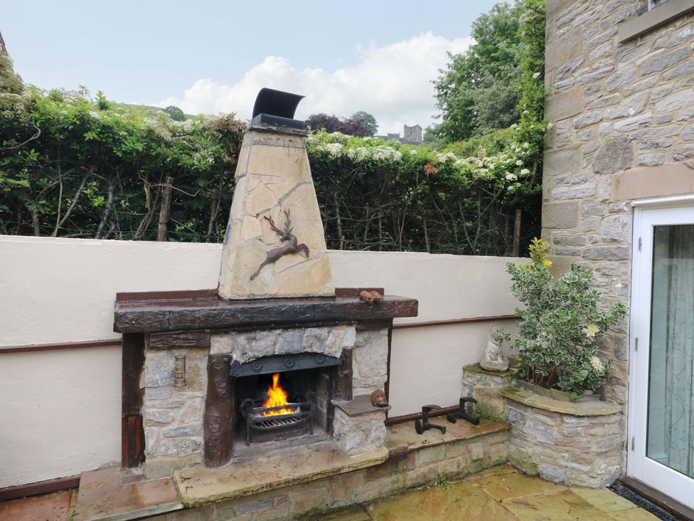 An outdoor fireplace with a chimney and plants at The Chimes in Hope Valley