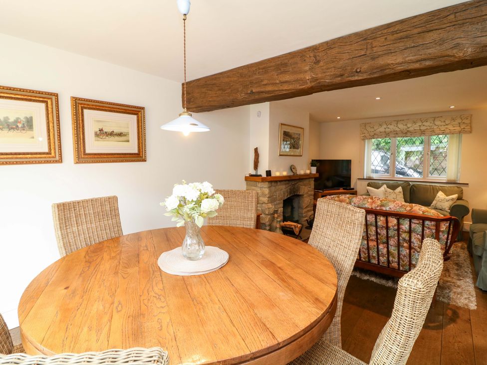 A dining room with a round table and chairs at The Chimes in Castleton, Peak District