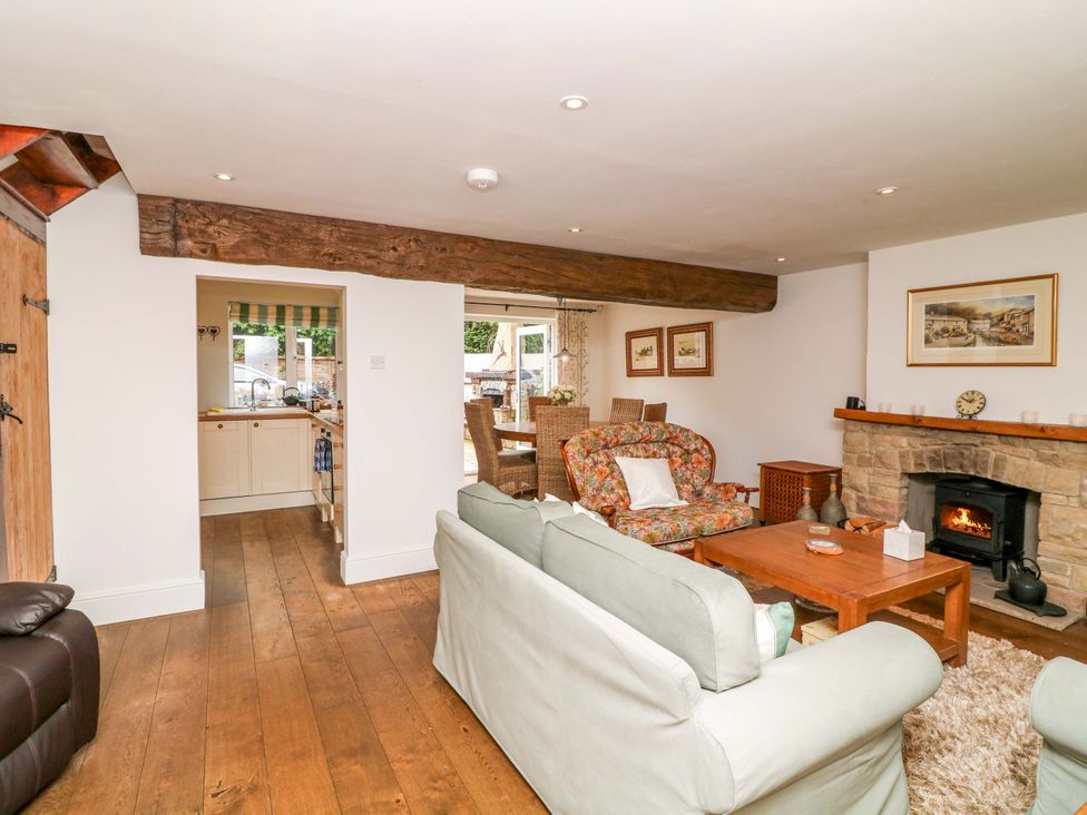 A living room with a sofa and fireplace at The Chimes in Castleton, Peak District