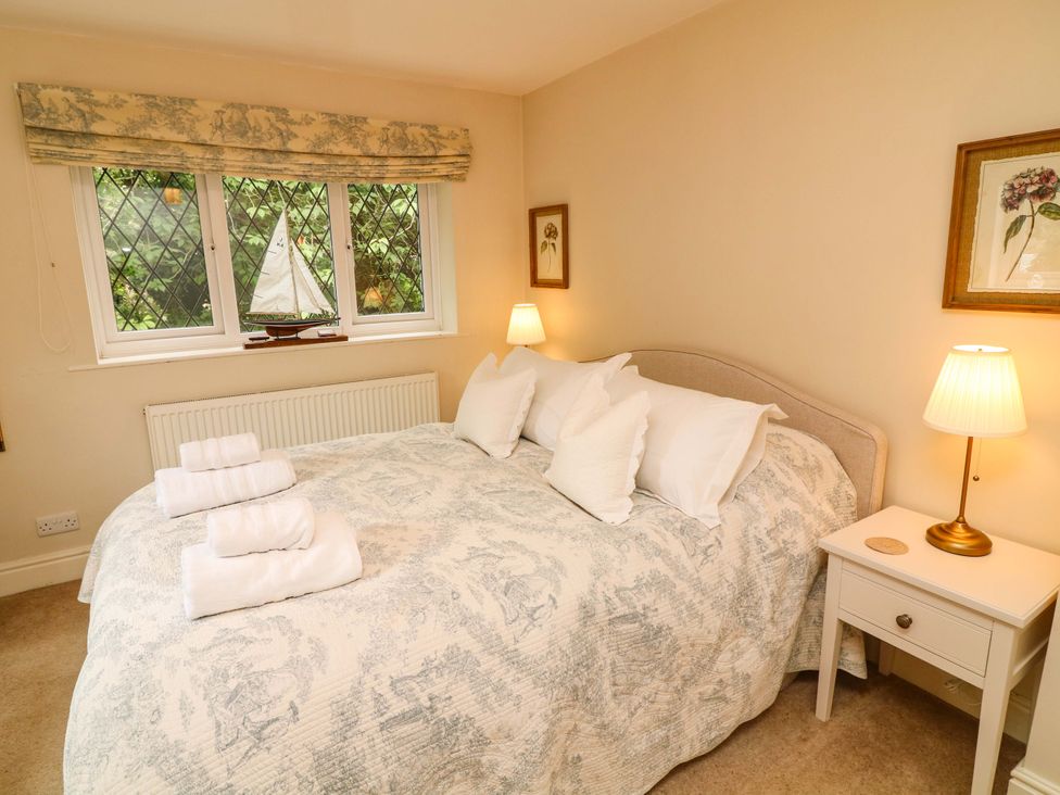 A bedroom with a bed, bedside table, and lamp at The Chimes in Castleton, Peak District