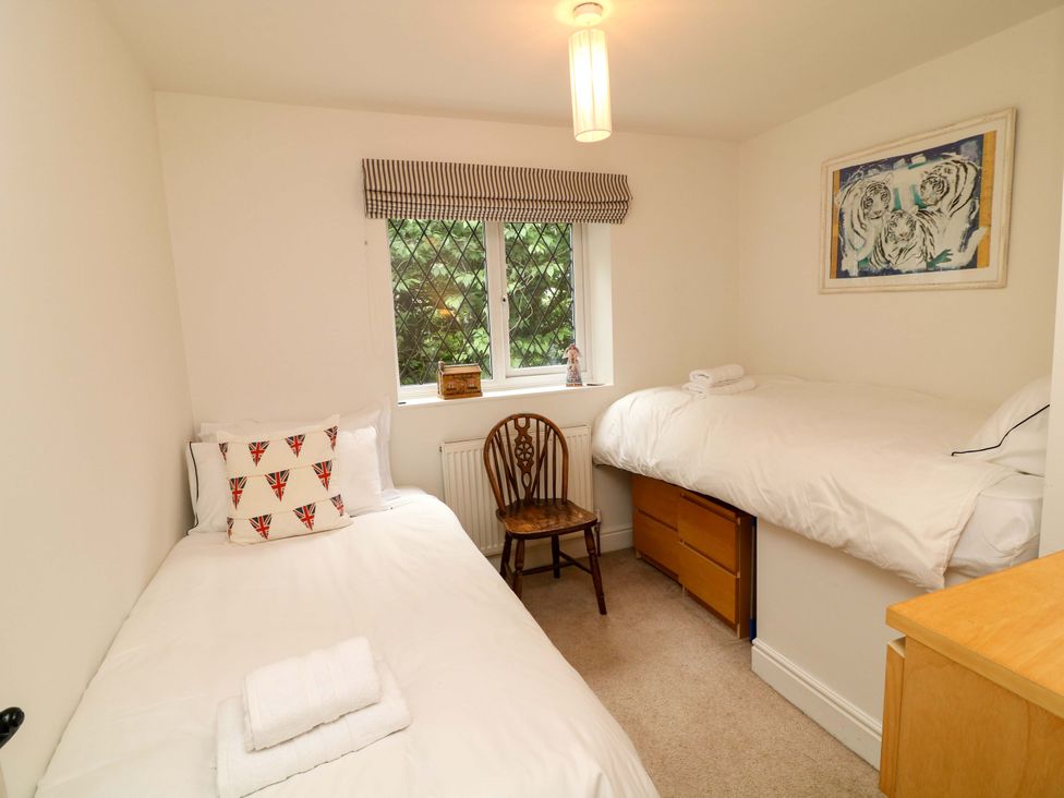 A bedroom with two beds and a chair at The Chimes in Castleton, Peak District
