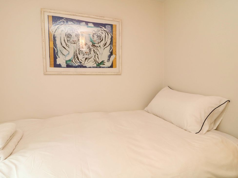 A bedroom with a bed, pillow, towel, and wall art at The Chimes in Castleton, Peak District