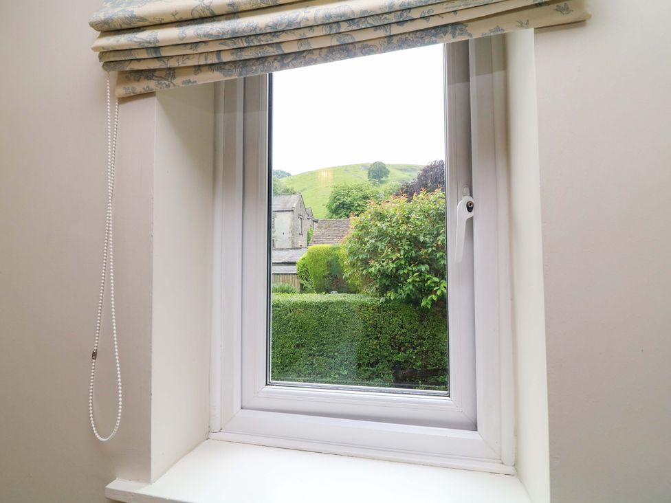 A window with a view of a garden and hills at The Chimes in Castleton, Peak District