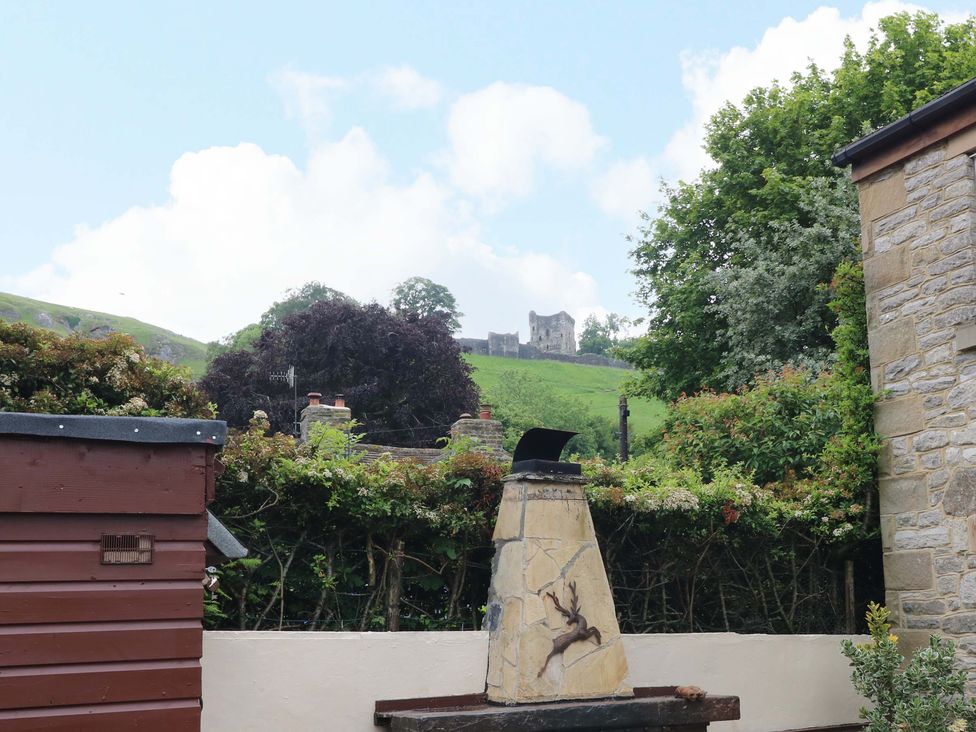 A garden with a chimney and hills in the background at The Chimes in Castleton, Peak District