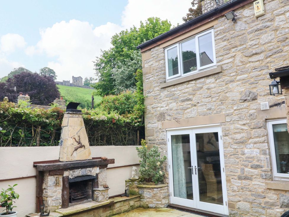 An outdoor area with a stone building and fireplace at The Chimes in Castleton, Peak District