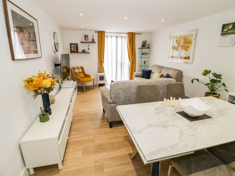 A living room with a sofa and dining table at 4 Goldcrest Close in Daventry