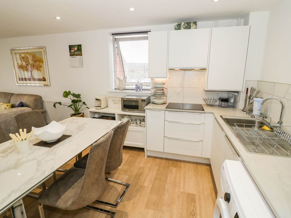 A kitchen with cabinets and a dining table at 4 Goldcrest Close in Daventry