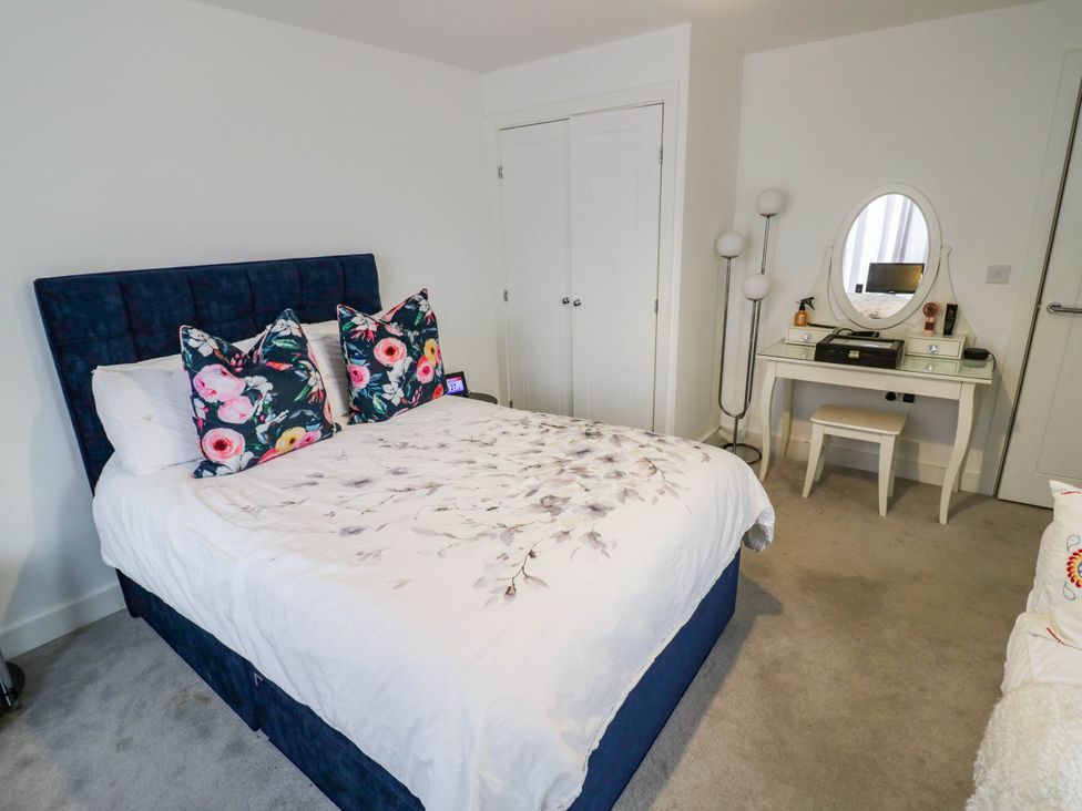 A bedroom with a bed and dressing table at 4 Goldcrest Close in Daventry