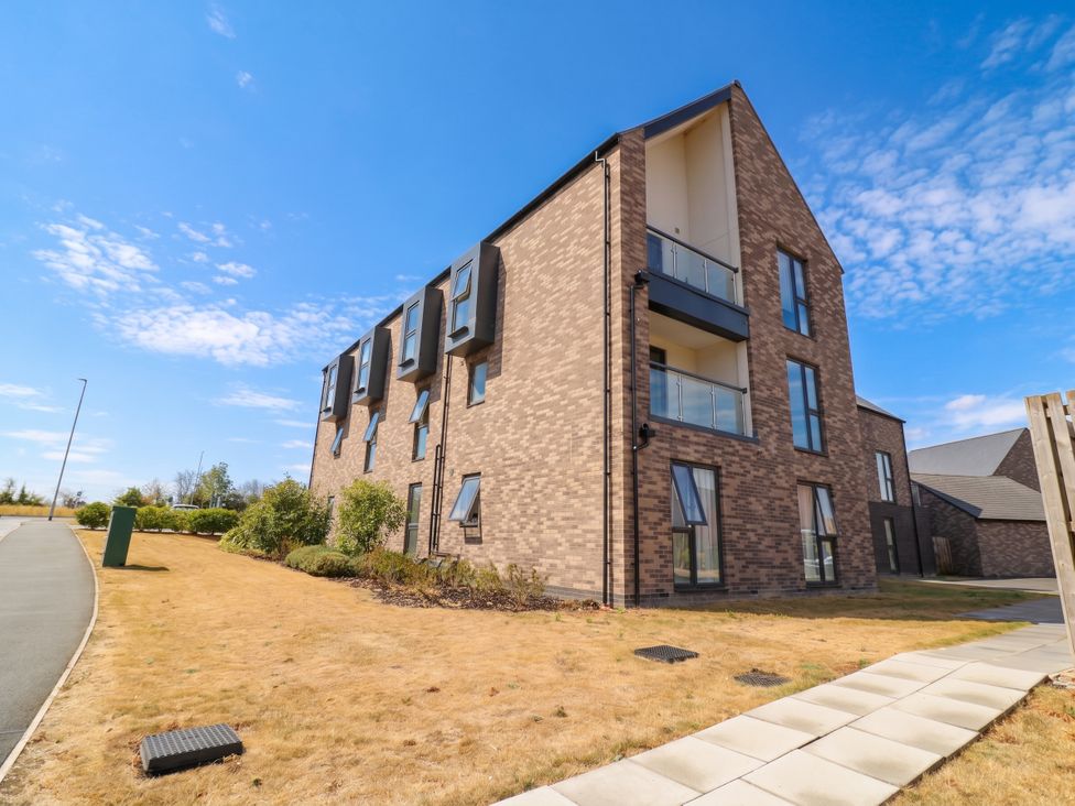 An apartment building with a pathway and greenery at 4 Goldcrest Close in Daventry