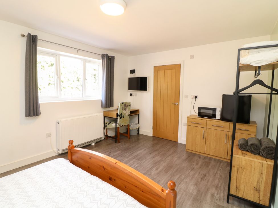 A bedroom with furniture including a desk and microwave at Walcott Lodges - Catley, Billinghay, Lincolnshire