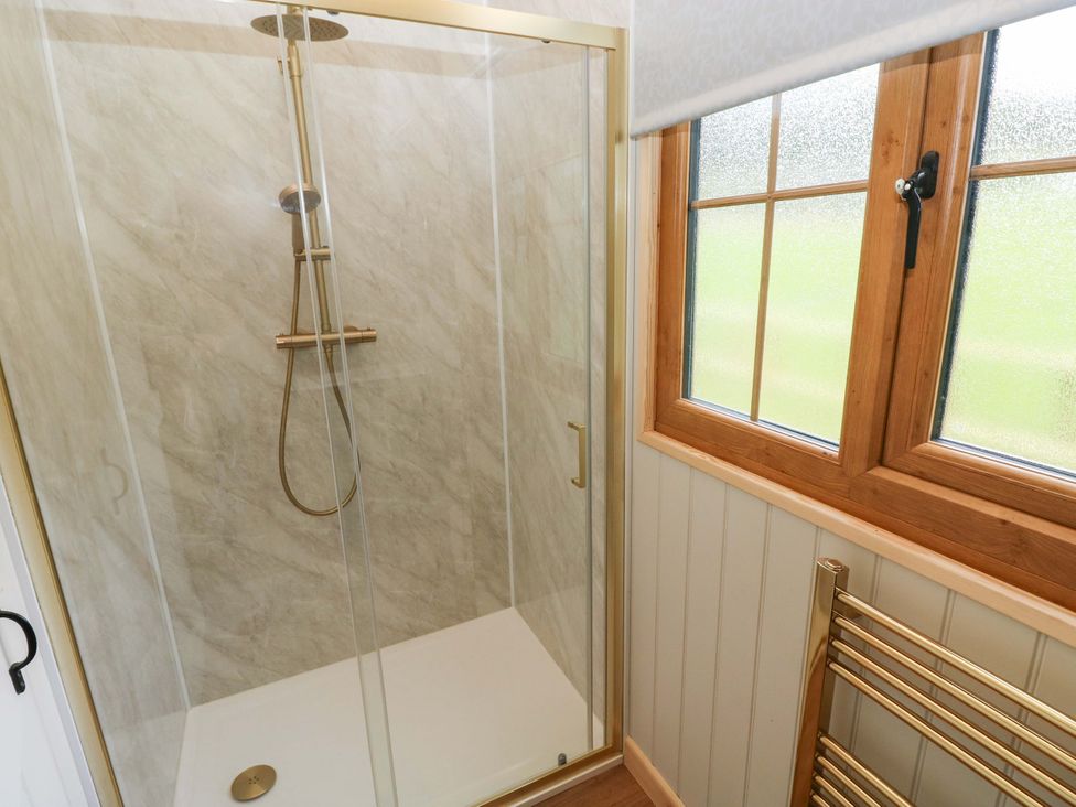 A shower enclosed with glass in a bathroom at Shepherd Hut 2 