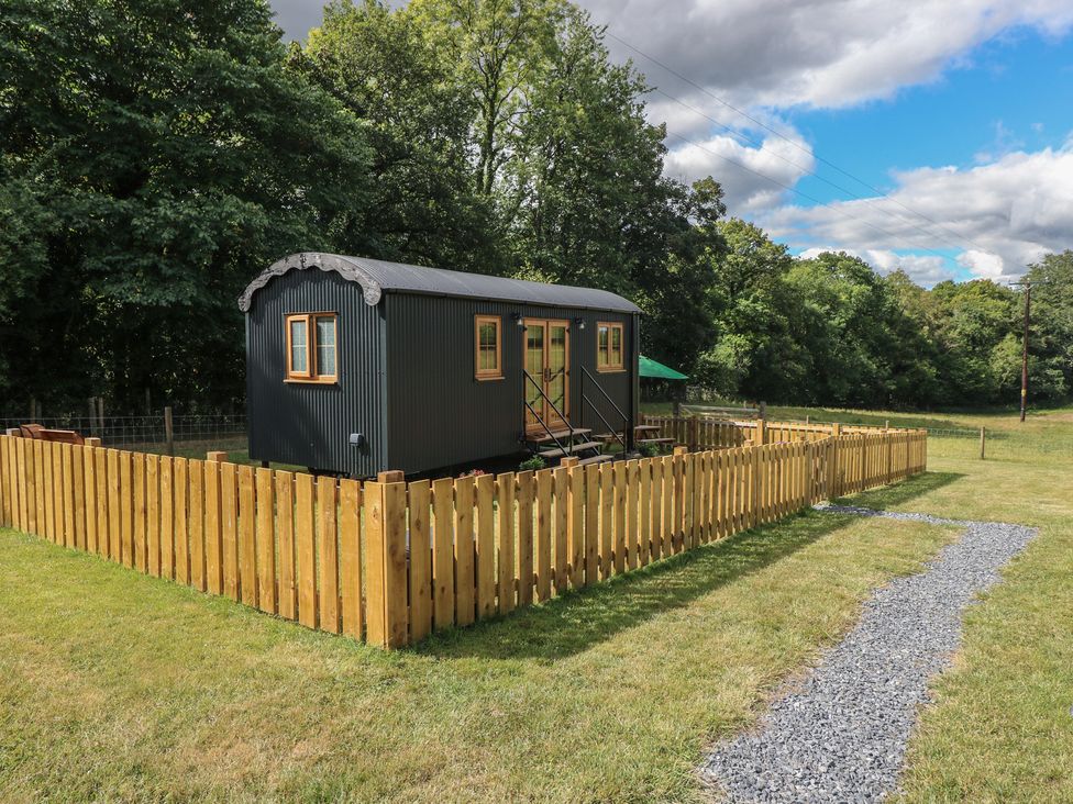 A cabin with a wooden fence and pathway at Cwtch Y Bugail 2 Near Llandeilo