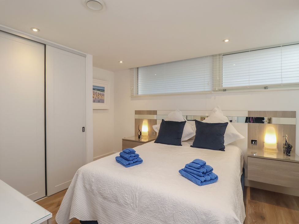 A bedroom with a bed and nightstands at 5 Sails in Dartmouth