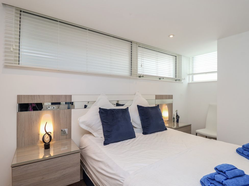 A bedroom with a bed and bedside table at 5 Sails in Dartmouth