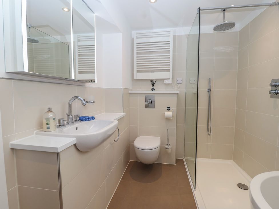 A bathroom with a sink, toilet, and shower at 5 Sails in Dartmouth